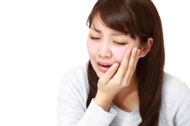 むし歯の痛みに苦しむ女性
